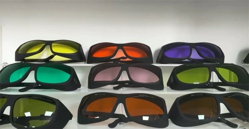 A variety of laser safety glasses displayed on a shelf