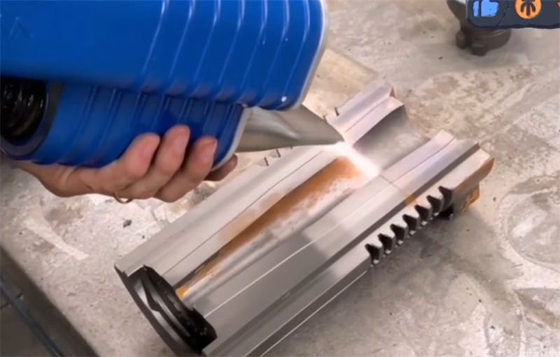 Laser cleaning technology being applied to remove rust from an industrial mold