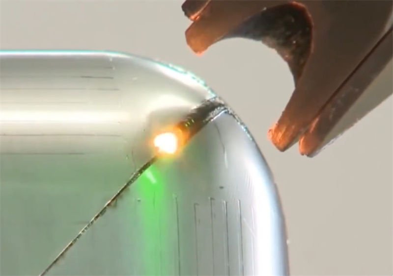 Precision laser welding being performed on a curved pipe joint