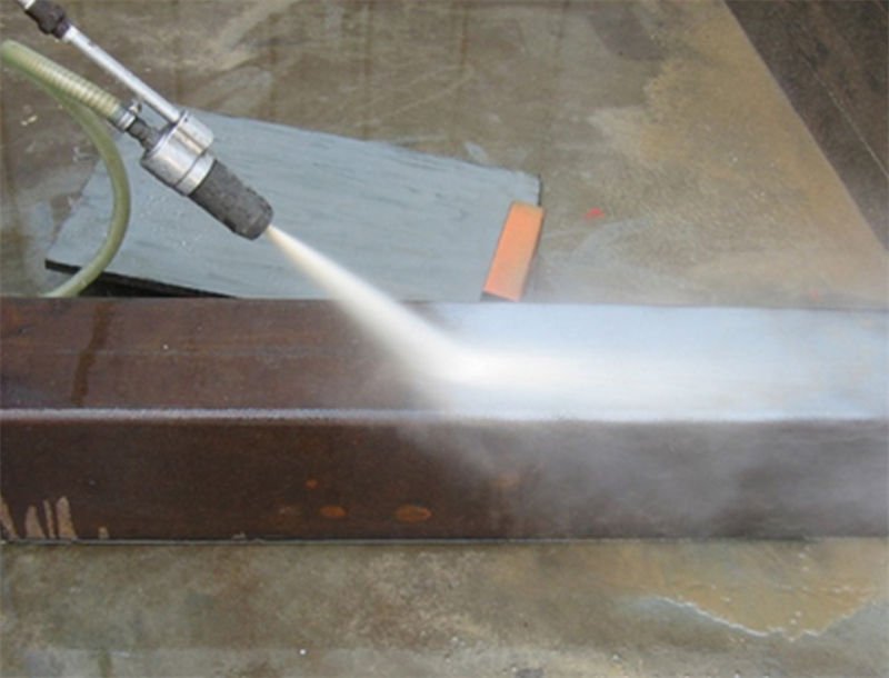 A beam of sand blasting used for rust removal on a metal beam
