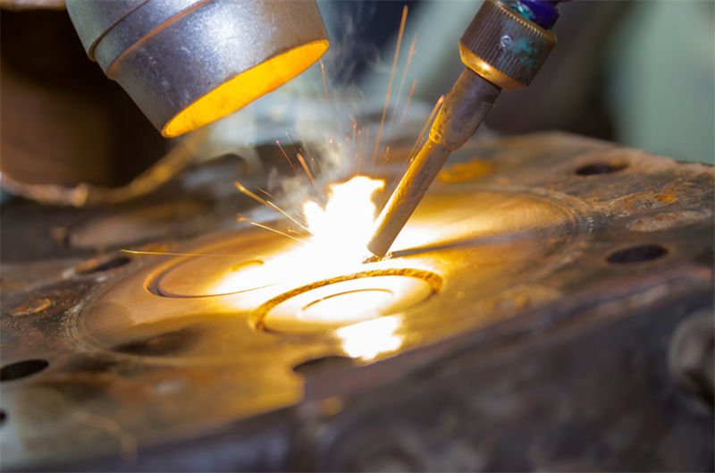 Close-up view of laser welding in action on a complex machine component