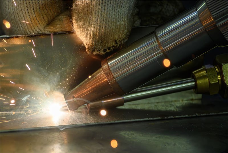  Close-up of a handheld laser welding device in operation, emitting sparks