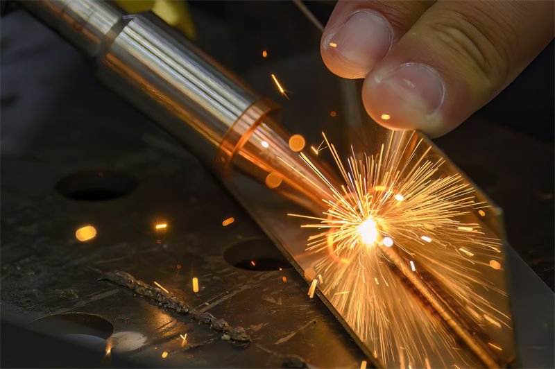 Close-up view of laser welding in progress, showcasing sparks flying as metal is fused together