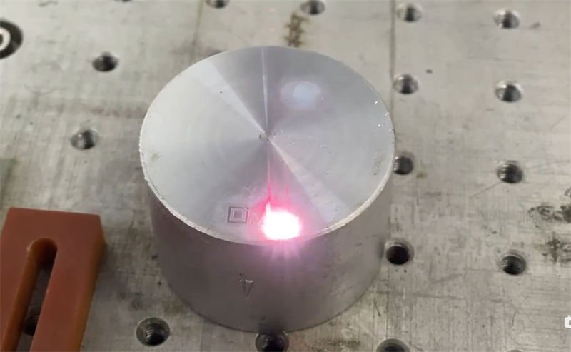 Fiber laser marking machine engraving a cylindrical metal object