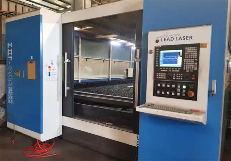 An industrial fiber laser cutting machine with a large cutting enclosure and a control panel on the right side