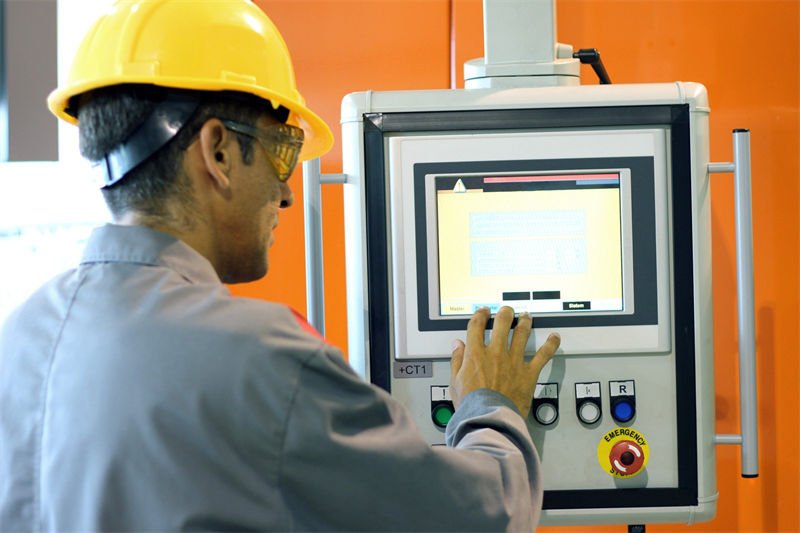 Engineer operating a CNC machine control panel