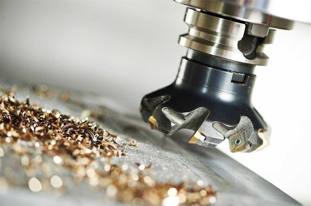 A close-up of a CNC milling cutter and metallic shavings on the work surface