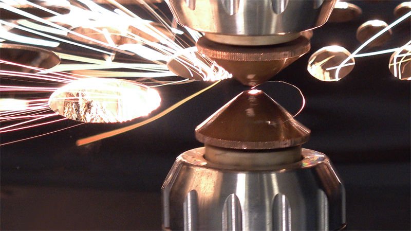Close-up of IPG fiber laser cutting metal with sparks flying during the process