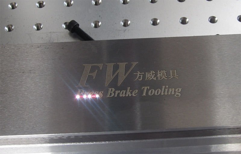 Laser marking machine engraving text and logo on a stainless steel surface