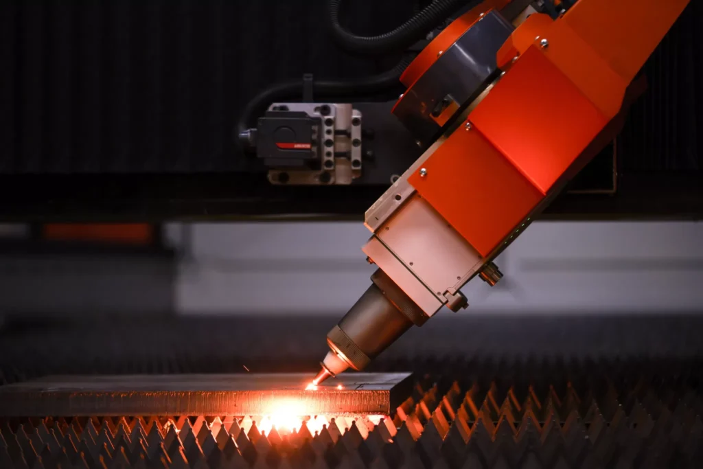 A close-up of a Nukon laser cutter performing 3D cutting on metal.