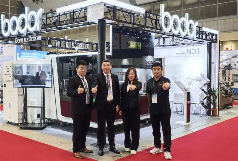 The Bodor team giving a thumbs-up in front of their exhibition booth at a trade show