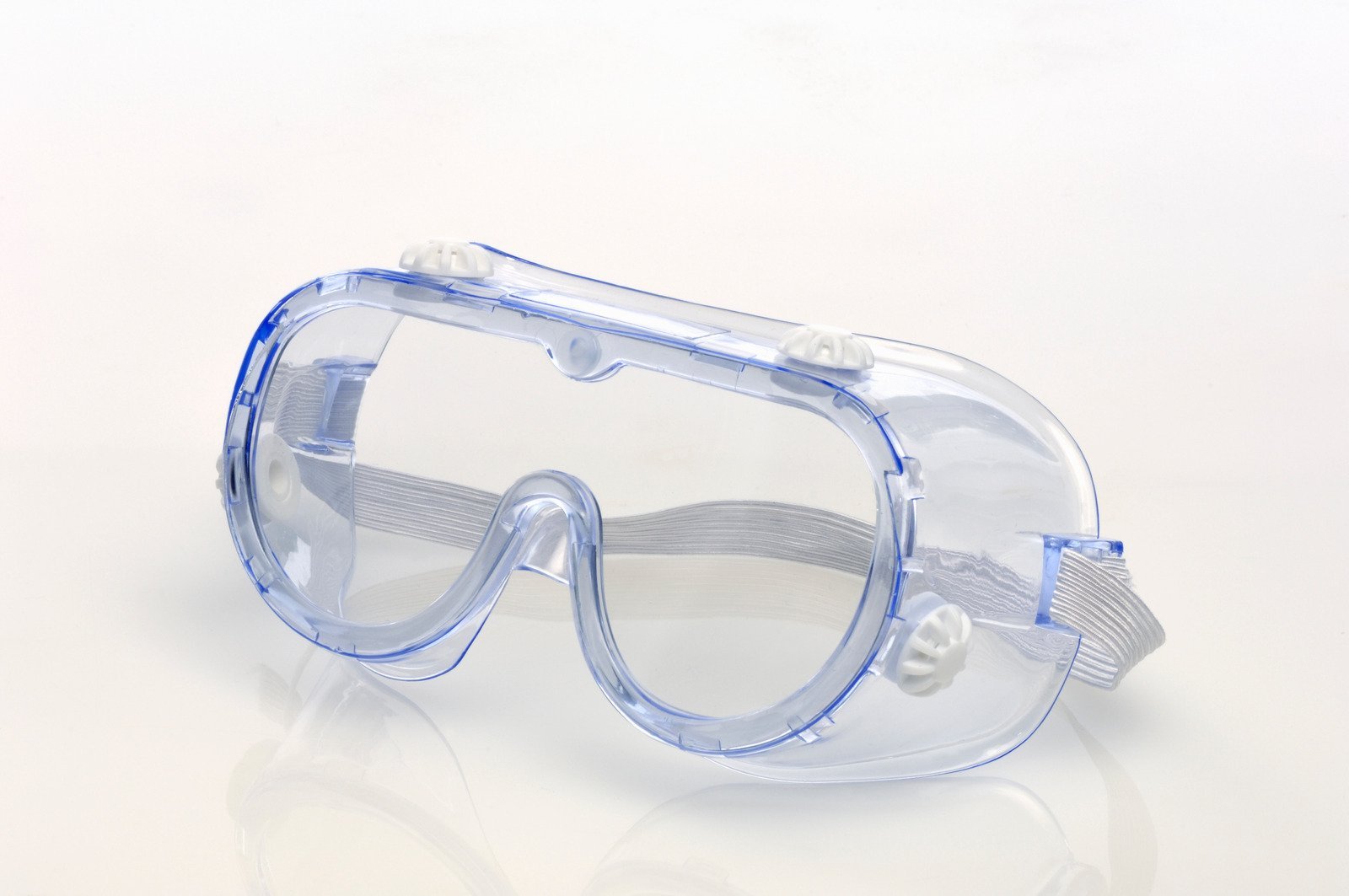 A transparent protective goggle with an elastic strap and ventilation ports, designed for workplace safety