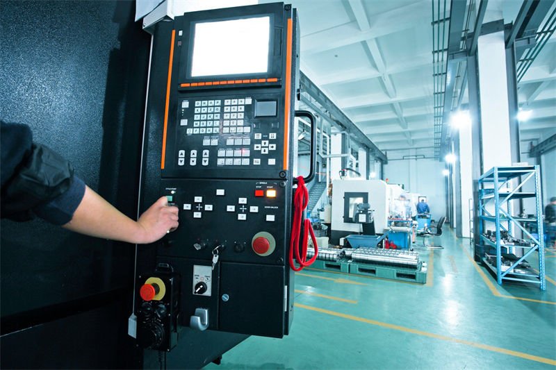 Operator adjusting Laser CNC machine settings in an industrial setting