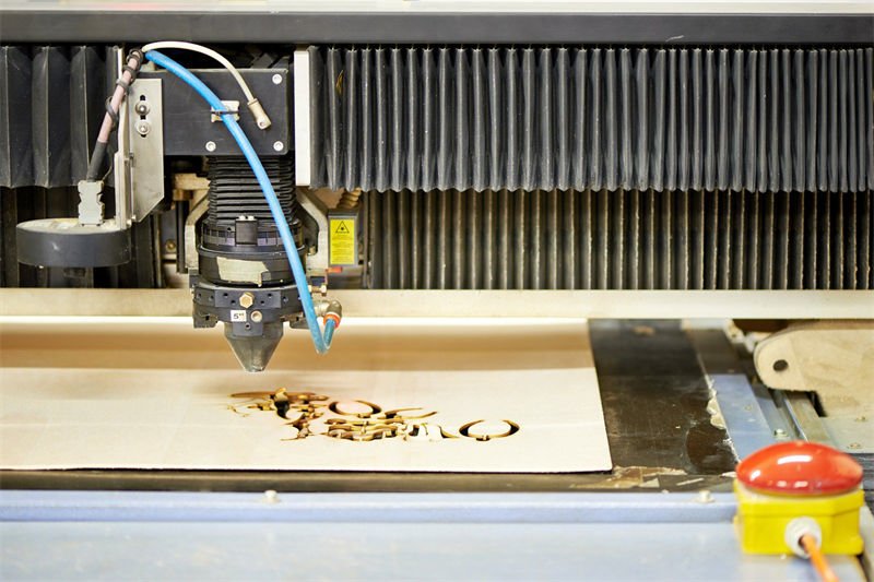 A CO2 laser engraver precisely engraving intricate patterns on a wooden board Title: CO2 Laser Engraving on Wood