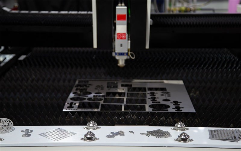 Laser cutting machine in operation, showcasing detailed metal cutouts.