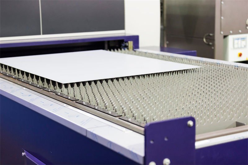 Hans Laser Fiber Laser Cutting Machine A close-up view of a fiber laser cutting machine by Hans Laser, featuring its bed with white metal sheet
