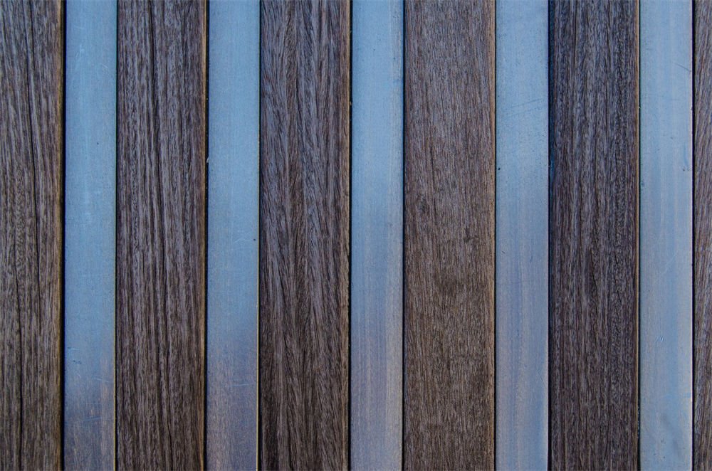 Alternating strips of wood and metal arranged vertically, showcasing precise laser processing and texture contrast