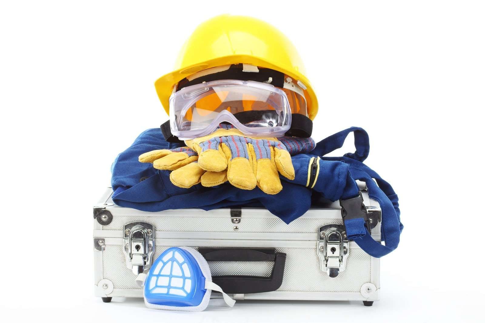 A set of personal protective equipment (PPE), including a hard hat, goggles, gloves, coveralls, and a respirator mask