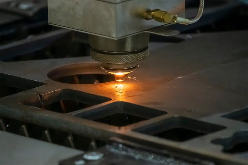 Close-up of a fiber laser cutting machine operating on a metal sheet