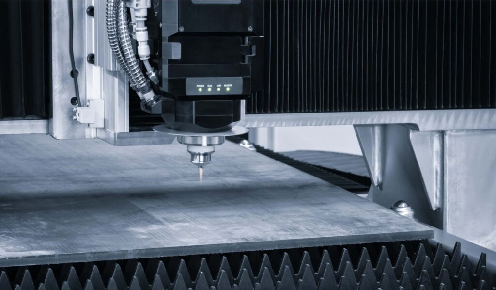 Close-up view of a laser cutting machine's head over a metal sheet, with precision focus on the cutting process in a clean and modern industrial setting.