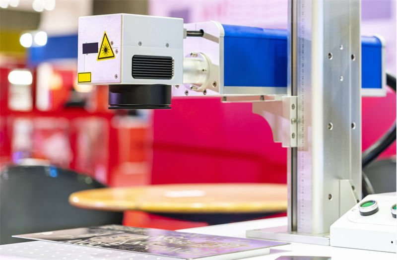 A close-up of a fiber laser marking machine focusing on a workpiece.