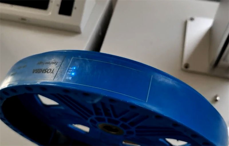Laser marking machine imprinting product information on a blue plastic surface