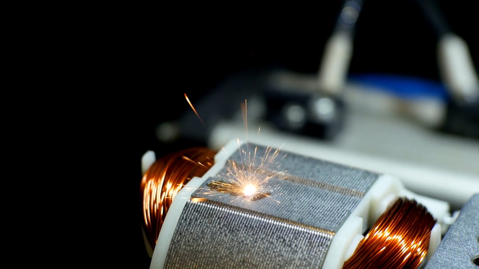 Laser marking a motor rotor with sparks during the process.