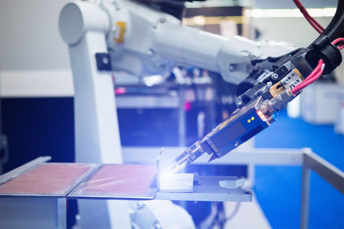 Robotic arm performing laser welding on metal components