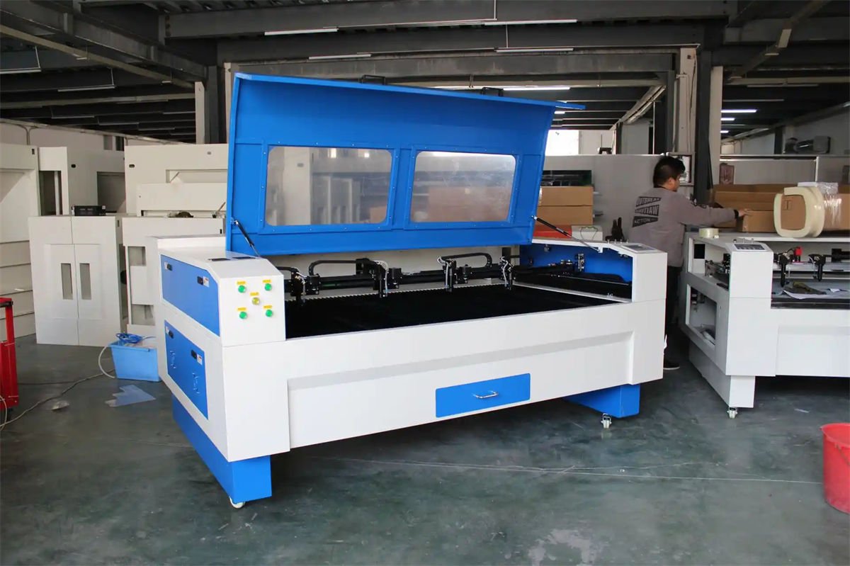 Four-head CO2 laser cutting and engraving machine with an open lid in a workshop environment