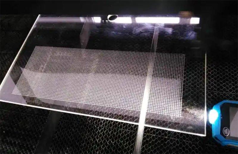 A sheet of glass with a grid-like pattern created using laser cutting technology